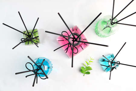 top view of luxury glass aroma reed diffuser bottle with blue , green and pink colour oil are...