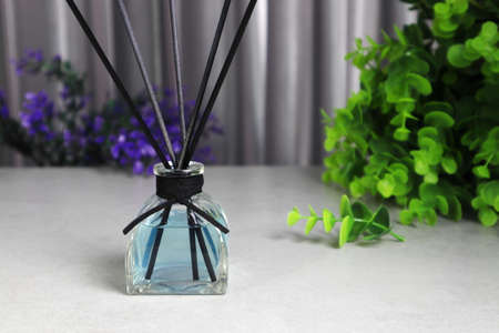 The stylish luxury glass aroma reed diffuser bottle display on the grey table in grey the bedroom of...