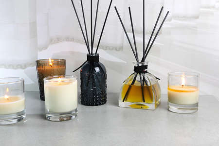 luxury nice glass candle and aroma room fresherner reed diffuser sticks are displayed on the grey...