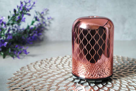 Luxury design rose gold colour aromatic humidifier diffuser machine display on the grey table in the...