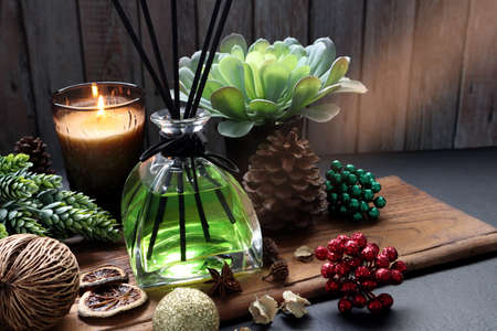 aromatic scented reed diffuser or air freshener are on wooden table decorated by various herb,...