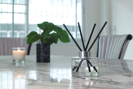 luxury aroma reed diffuser crystal glass bottle is on the white marble table to creat romance and...