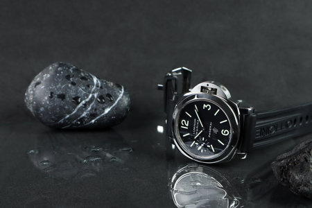 The wrist watch brand Panerai or Pam model 005 is displayed on the black wet glass table shelf with black background in the authorized dealer Panerai shop in luxury watch eventのeditorial素材