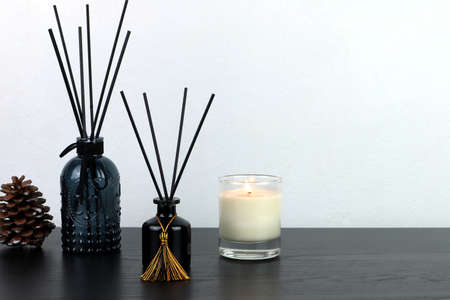 many design of luxury aroma scent reed diffuser glass bottle are on wooden table with scented candle...