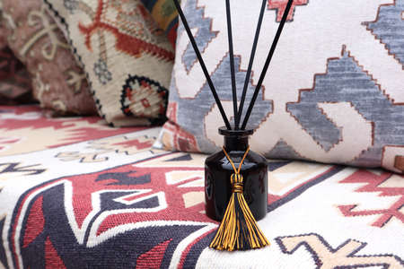 luxury aromatic scented reed diffuser black glass bottle display on the nice colorful carpet in the...