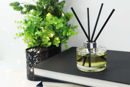 luxury aroma scent reed diffuser glass bottle is on white table with books to creat romantic and...