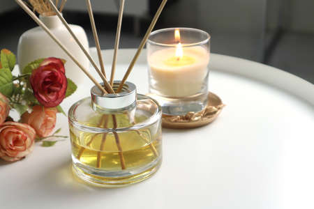luxury aromatic scent of reed diffuser glass bottle is used as room freshener on the white metal table in the bedroom to creat relax and romantic ambient with background of nice beの写真素材