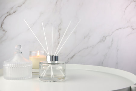 luxury aromatic scent of reed diffuser glass bottle is used as room freshener on white steel  table...