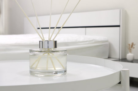 luxury aromatic scent of reed diffuser glass bottle is used as room freshener on white steel table...