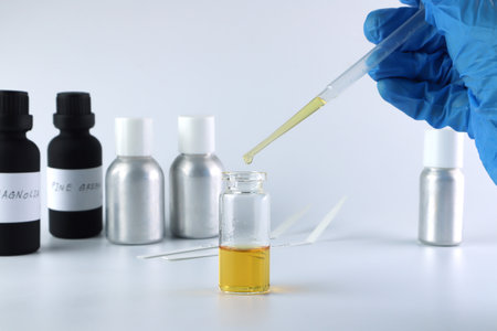 chemical beaker , flask is on white table with blotting paper , fragrance bottle and essential oil bottle are used to blend the nice scent for making perfume and candle by perfumerの写真素材