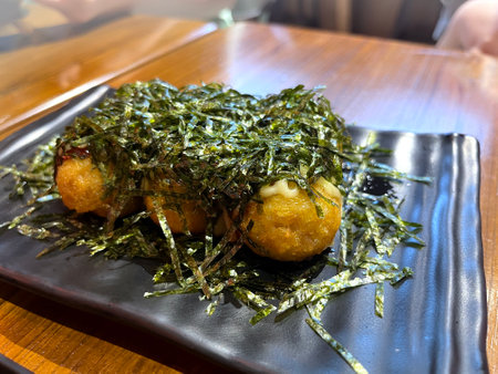 takoyaki is served on wooden table , ball-shaped Japanese snack made of a wheat flour-based butter and cooked in a special molded pan. filled with minced or diced octopus (tako), oの写真素材