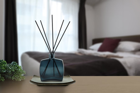 luxury aroma scent reed diffuser glass bottle is on the wooden table and golden ceramic holder to...