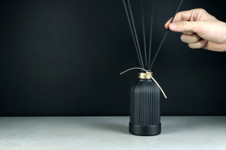 luxury aroma scent reed diffuser black glass bottle are on grey stone table to creat romantic and...