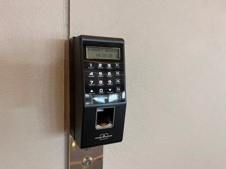 modern fingerprint access control is installed on wall in front of building to ensure secure access...