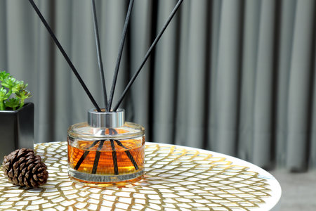 luxury aroma scent reed diffuser glass bottle is on white marble table with essential oil bottle and...