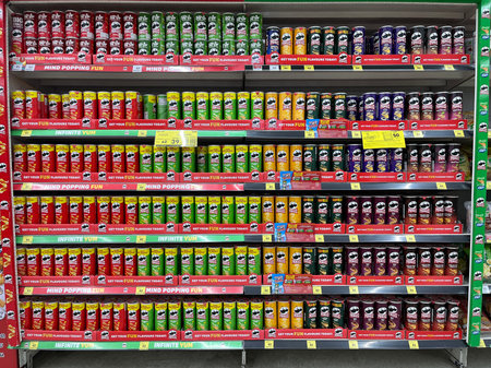 colorful supermarket shelf fully stocked with Pringles potato chips in various flavors. Bright...