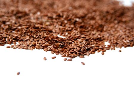 heap of brown flax seeds isolated on white backgroundの写真素材