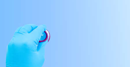 Hand in gloves with a stethoscope on a blue background. medical background. copy space