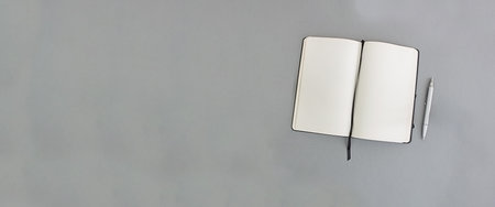 Notebook and pen on a gray background, copy space. Bannerの写真素材