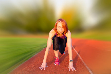 Beautiful woman on the race track is ready to run.