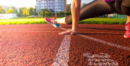 A woman warms up before training on a public sports field.