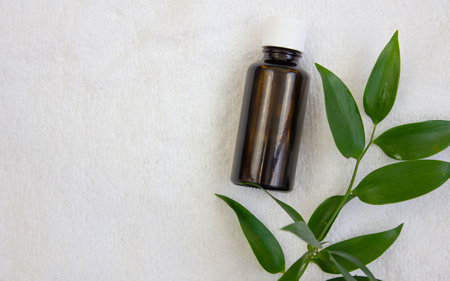 A bottle of essential oil on a white towel. copyspace.の写真素材