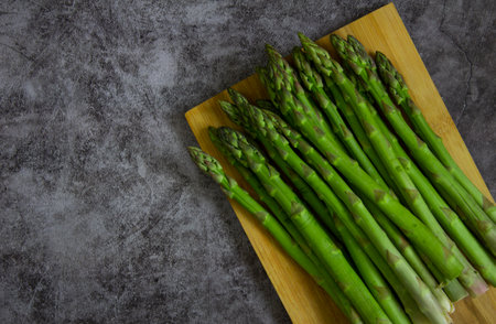 Green asparagus on a dark stone background, close up.の写真素材
