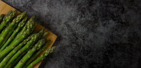 Green asparagus on a dark stone background, close up. copy spaceの写真素材