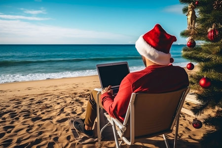 Man in a Santa Claus hat is working on a laptop on the beach. Celebrating Christmas in warm countries. Image generated by AI.の素材