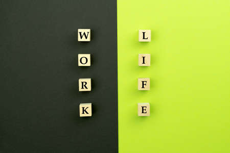 Work and life. Wooden cubes on a black green background. Concept of balance, harmony, no stress....