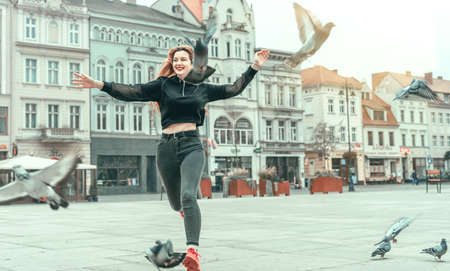 Pretty girl with backpack on background of sky with birds. Carefree traveling happy woman. Journeyの写真素材