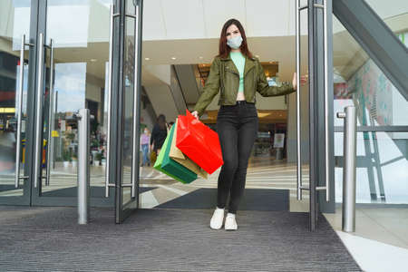 Pretty woman choosing groceries at supermarket. Female consumer purchasing goods at mall, walking among shelves. Girl with mask shopping of foodの写真素材