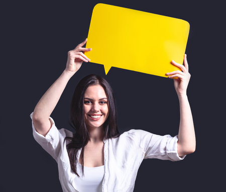 Smiling woman holding blank billboard. Girl in white shirt with poster frameの写真素材