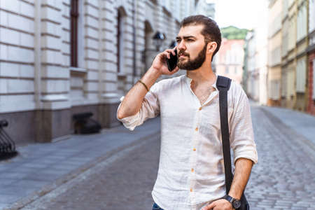 Guy walking down on street. Young man in casual styleの写真素材