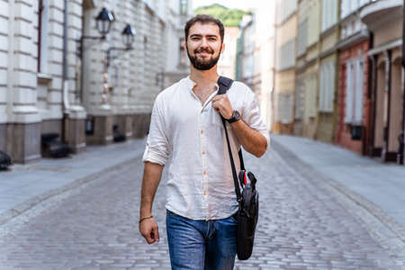 Guy walking down on street. Young man in casual styleの写真素材