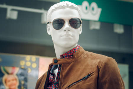 POLAND, BYDGOSZCZ - February 11, 2020: Portrait of male mannequin in brown jacket, shirt and aviator sunglasses. White dummy in shop window men's clothing. Shoppingのeditorial素材