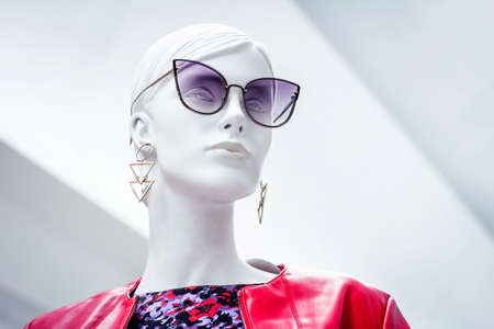 Mannequin face. Bright portrait of female beautiful dummy in purple sunglasses with earrings on isolated white background. Fashion industryのeditorial素材