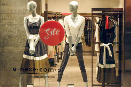 POLAND, BYDGOSZCZ - March 1, 2020: Female mannequins show spring clothes collection. Standing dummies in store window. Dress, trousers and white blouse. Female shopping. Advertising Saleのeditorial素材