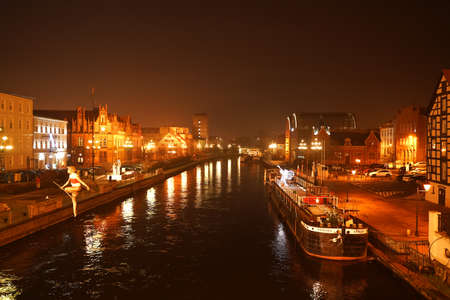 POLAND, BYDGOSZCZ Mai 3, 2020: Cityscape seen from a bridge with tightrope walker sculpture over Brda river. Old town architecture on a sunny spring dayのeditorial素材