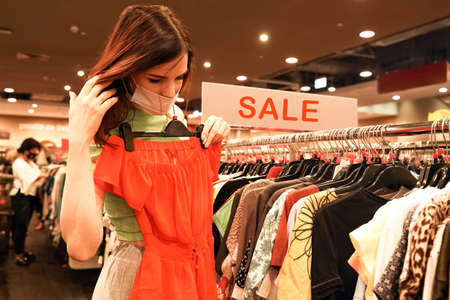 Purchaser near red poster 50 percent sale. Store, shop window. Consumerismの写真素材