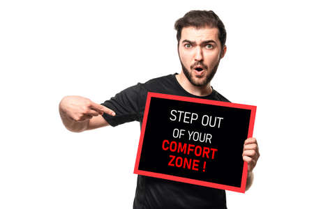 Step out of your comfort zone. Emotional man show frame with motivation call to action. Guy on isolated background in studioの写真素材
