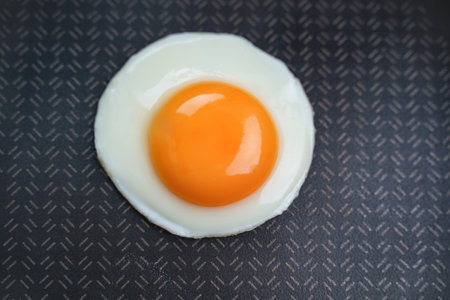 Fried egg in a pan. Black background. top viewの写真素材