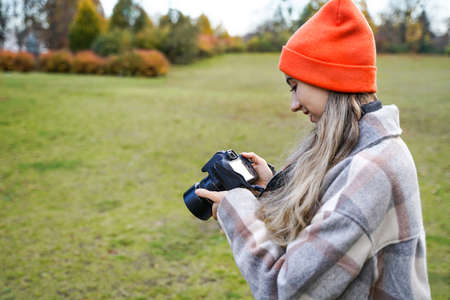 girl with camera outdoors. woman takes pictures. Hobby leisure or professionの写真素材
