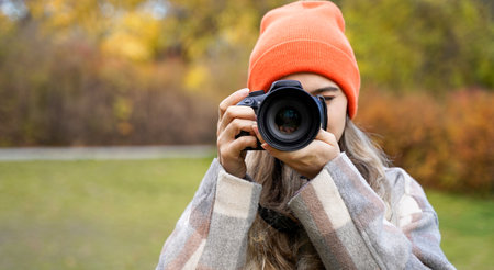 girl with camera outdoors. woman takes pictures. Hobby leisure or professionの写真素材