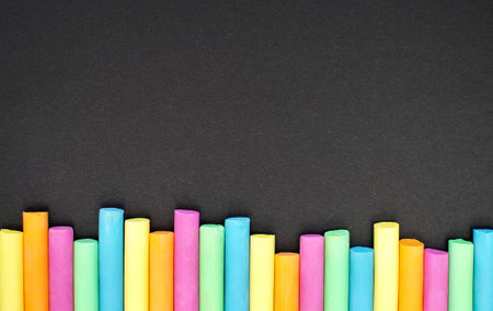 Colored chalk on black background. education concept. back to school. Space for your textの写真素材