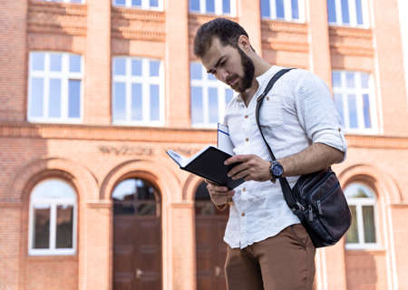 Confident handsome man. Young business man in white shirt talking on phone outdoors. Self employed professional. business negotiationsの写真素材