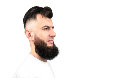 Portrait of a dark haired man with a stylish hairstyle and beard. Male profile isolated on white background. Care for a beard. hair cutの写真素材