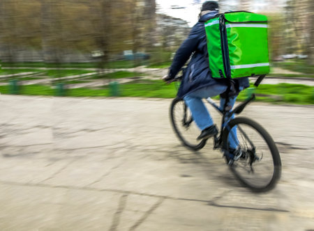 Motion blur, a courier on a bicycle is in a hurry to deliver an orderの写真素材