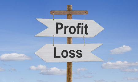 White wooden arrows with the inscription: profit, loss are suspended from a rope on a wooden stand.