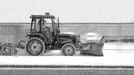 Clearing the sidewalk from snow using road equipmentの写真素材